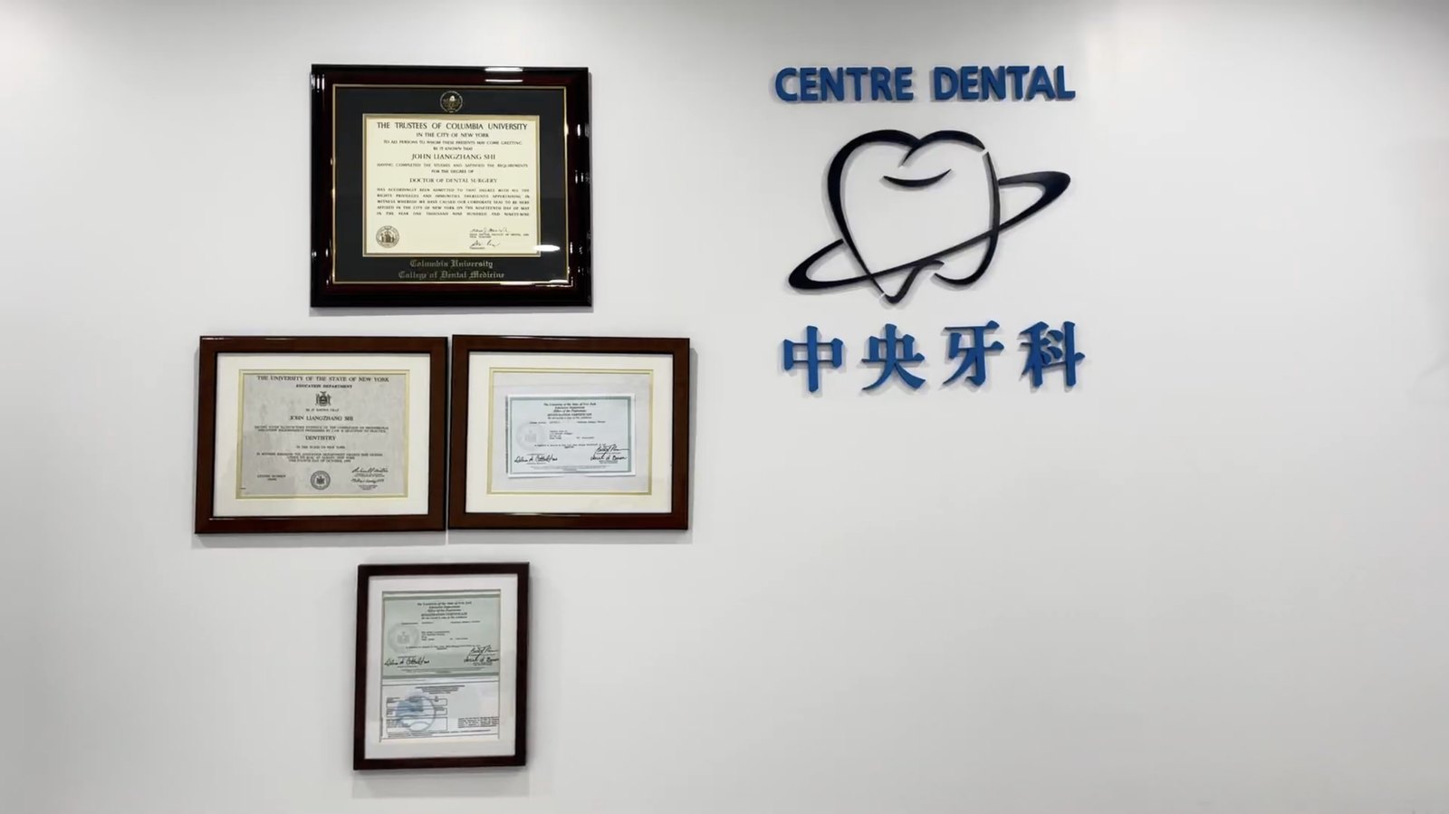 Centre Dental NYC office wall with Columbia University dental diplomas and the 中央牙科 Centre Dental logo